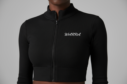 CLOSE-UP STUDIO PHOTO OF A BLACK FEMALE MODEL WEARING A BLACK RIBBED LONG-SLEEVE CROPPED ZIP TOP LIKE THE REFERENCE IMAGE.
FABRIC TEXTURE MUST BE CLEAR — TIGHT RIBBED KNIT, SMOOTH AND STRETCHY.
“WARRA” WRITTEN IN SMALL WHITE CURSIVE ACROSS THE UPPER CHEST, CENTERED LIKE A NIKE LOGO.
THE CURSIVE FONT MUST BE REALISTIC, FLOWING, AND ELEGANT WITH A DISTINCT “W”.
SOFT STUDIO LIGHTING, NEUTRAL BACKGROUND, FOCUS ON FABRIC AND LOGO DETAIL.
NO TEXT, NO DISTRACTIONS, JUST MODEL AND TOP.