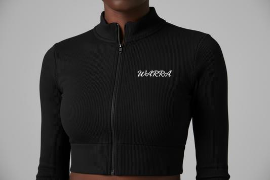 CLOSE-UP STUDIO PHOTO OF A BLACK FEMALE MODEL WEARING A BLACK RIBBED LONG-SLEEVE CROPPED ZIP TOP LIKE THE REFERENCE IMAGE.
FABRIC TEXTURE MUST BE CLEAR — TIGHT RIBBED KNIT, SMOOTH AND STRETCHY.
“WARRA” WRITTEN IN SMALL WHITE CURSIVE ACROSS THE UPPER CHEST, CENTERED LIKE A NIKE LOGO.
THE CURSIVE FONT MUST BE REALISTIC, FLOWING, AND ELEGANT WITH A DISTINCT “W”.
SOFT STUDIO LIGHTING, NEUTRAL BACKGROUND, FOCUS ON FABRIC AND LOGO DETAIL.
NO TEXT, NO DISTRACTIONS, JUST MODEL AND TOP.
