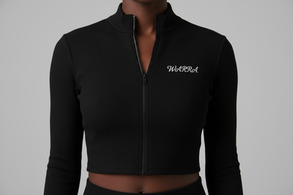 CLOSE-UP STUDIO PHOTO OF A BLACK & wHITE FEMALE MODEL WEARING A BLACK RIBBED LONG-SLEEVE CROPPED ZIP TOP LIKE THE REFERENCE IMAGE.
FABRIC TEXTURE MUST BE CLEAR — TIGHT RIBBED KNIT, SMOOTH AND STRETCHY.
“WARRA” WRITTEN IN SMALL WHITE CURSIVE ACROSS THE UPPER CHEST, CENTERED LIKE A NIKE LOGO.
THE CURSIVE FONT MUST BE REALISTIC, FLOWING, AND ELEGANT WITH A DISTINCT “W”.
SOFT STUDIO LIGHTING, NEUTRAL BACKGROUND, FOCUS ON FABRIC AND LOGO DETAIL.
NO TEXT, NO DISTRACTIONS, JUST MODEL AND TOP.